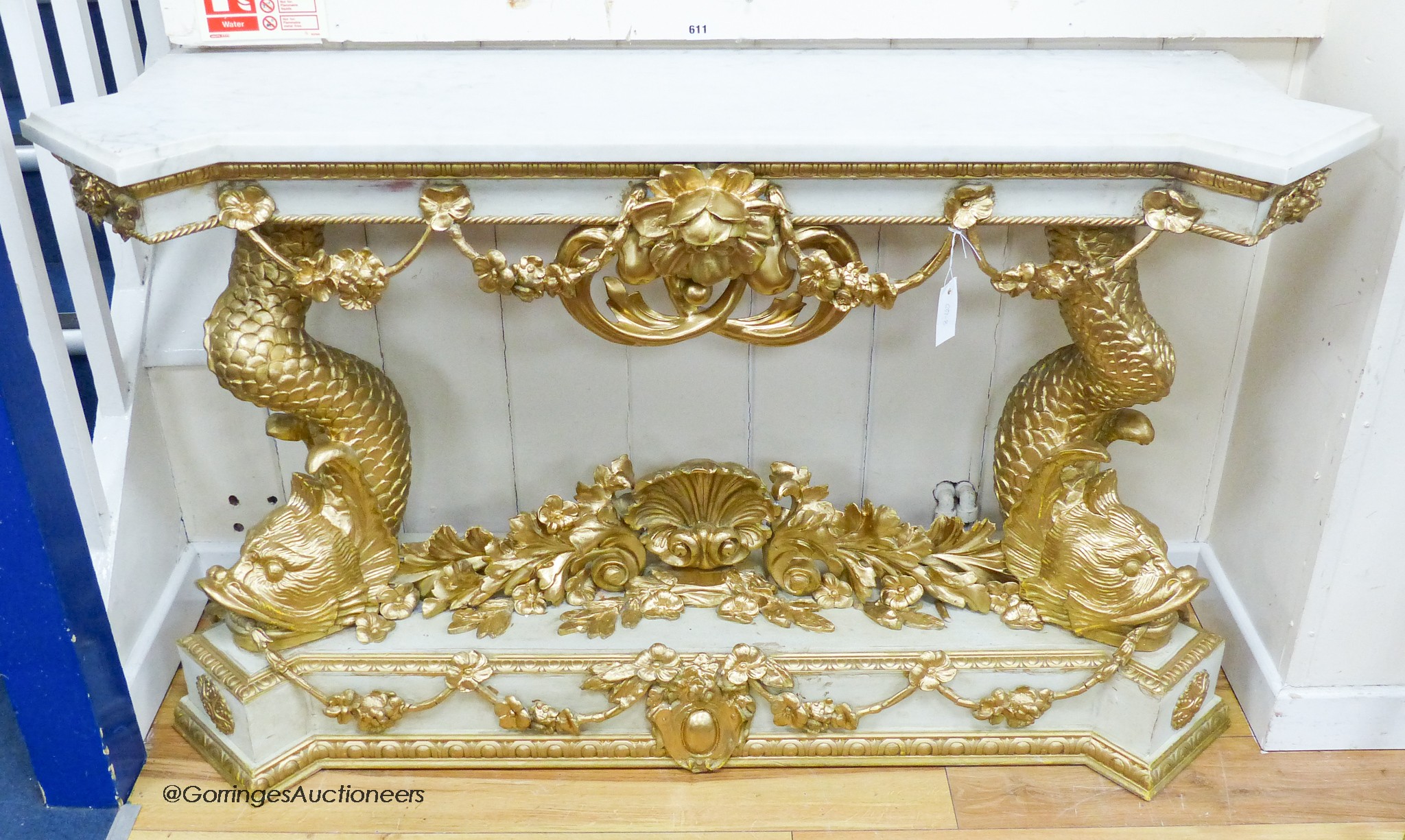 A Louis XVI style painted composition and giltwood console table on dolphin supports, width 146cm, depth 43cm, height 85cm